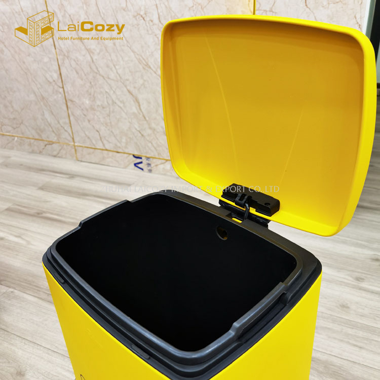 Cubo de basura amarillo interior con pedal de recolección de máscaras usadas en el hospital